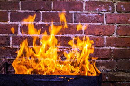 fire and grill over red brick wall background in backyard.の写真素材