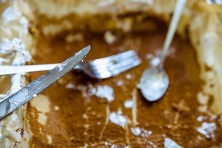 fork knife and spoon covered with apple pie icing on empty baking paper trayの写真素材