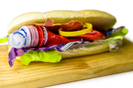 Hotdog filled with plastic waste and paper cardboard. Recycled waste in our food conceptの写真素材