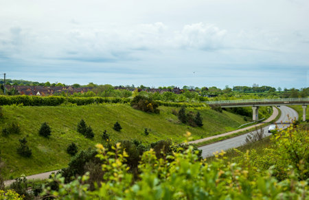 uk motorway road traffic over new build town development in england.