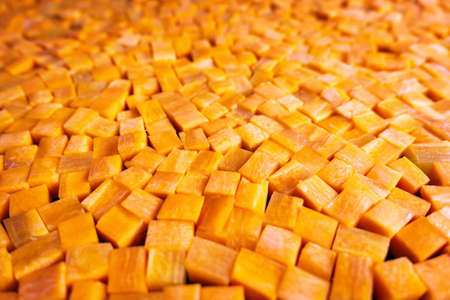 Fresh carrot cube pieces closeup backgroundの写真素材
