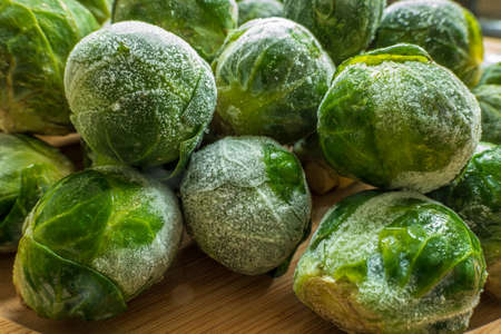 frozen frosty brussels sprouts on wooden plate closeupの写真素材