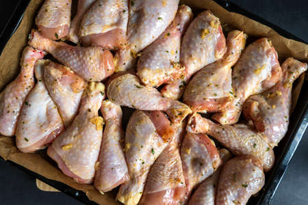 raw chicken drumsticks on baking tray prepared for ovenの写真素材