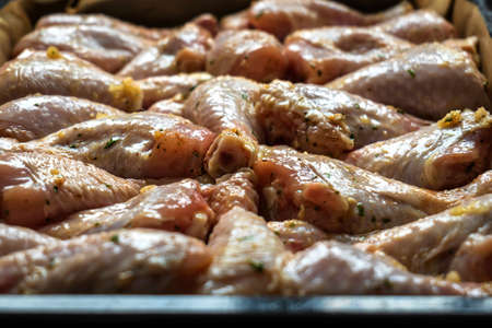 raw chicken drumsticks on baking tray prepared for ovenの写真素材