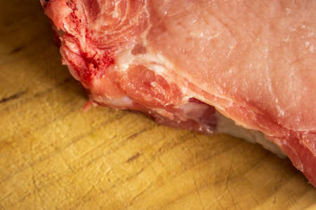 fresh raw pork chops on wooden cutting board closeupの写真素材
