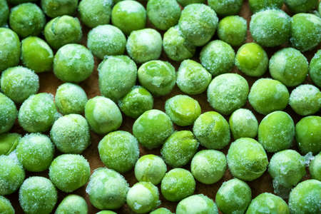frozen frosty green peas background closeupの写真素材
