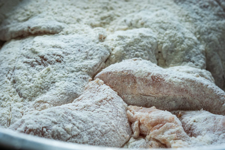 raw chicken breast fillet flour covered closeup.