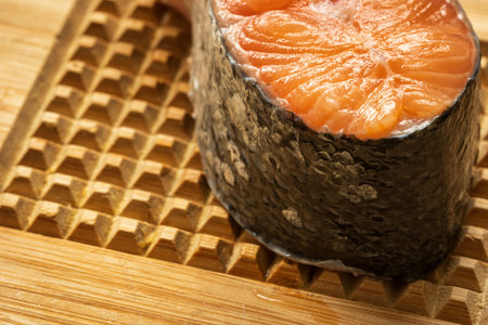 raw salmon filet on wooden cutting board