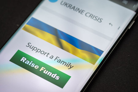 Close-up finger pressing raise funds button on smartphone screen. Donation money online concept