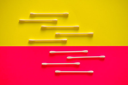 Cotton swab on a pink background.