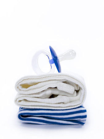 baby pacifier and clothes in blue color on a white background