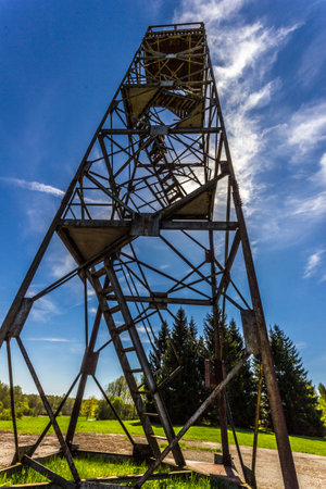 Old rusty mine shaft against the blue sky with clouds in the summerの写真素材