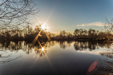 Sunset on the river in the spring. The sun is reflected in the water.