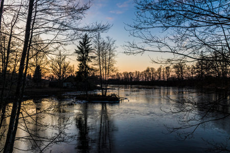 Landscape with a frozen river in the early spring at sunset, Polandの写真素材