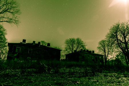 abandoned house at night with stars and moon in the skyの写真素材