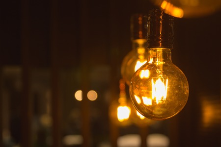 A glowing light bulbs. Light bulbs on a dark background with copy space.の写真素材