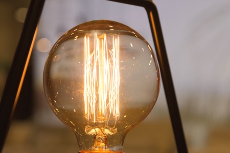 A glowing light bulb. Light bulb on a light background.の写真素材