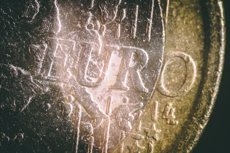 macro view of the scratched one euro coin in the darknessの写真素材
