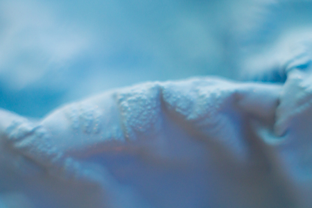 a close-up view of the compressed wrinkled rubber of a blue sea color with a blurred background. abstract wallpaperの写真素材