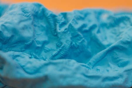 a close-up view of the compressed wrinkled rubber of a blue sea color with a blurred background. abstract wallpaperの写真素材