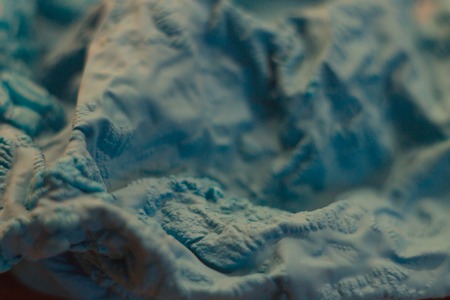 a close-up view of the compressed wrinkled rubber of a blue sea color with a blurred background. abstract wallpaperの写真素材