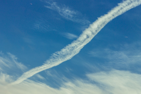 blue sky with cirrus clouds with a strip from the airplaneの写真素材