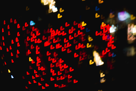 The bokeh of heart shape from the beautiful colourful light decoration at nightの写真素材