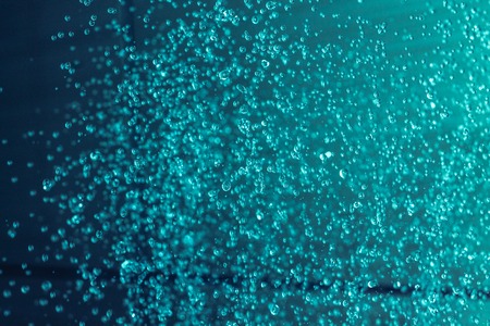 water droplets frozen in flight, cyan bacgroundの写真素材