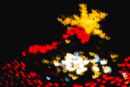 The bokeh of heart shape from the beautiful colourful light decoration at nightの写真素材