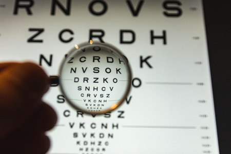 negative concave ophthalmic lens on a blurred background of the ETDRS eye testの写真素材