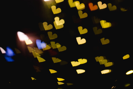 The bokeh of heart shape from the beautiful colourful light decoration at nightの写真素材