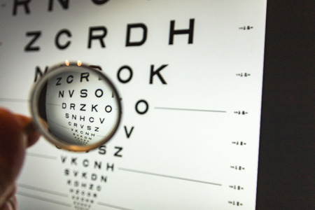 negative concave ophthalmic lens on a blurred background of the ETDRS eye testの写真素材