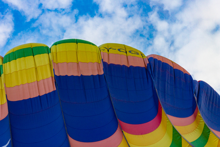 part of a multi-colored balloon against a cloudy skyの写真素材