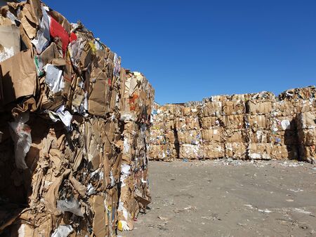 Stack of paper and cardboard garbage at recycling planの写真素材