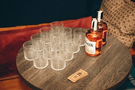 Vilnius, Lithuania - June 8, 2019: Glasses placed on the table next to two bottles of whiskey and banknotesのeditorial素材