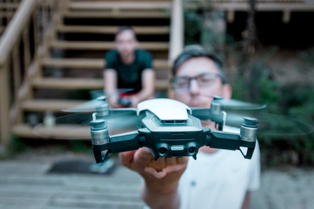 Vilnius, Lithuania - June 8, 2019: Man holding DJI MAVIC AIR - drone with camera, mounted on a...