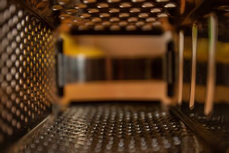 View from inside the kitchen grater. Texture of a metal surface with holes. Selective focus.の写真素材