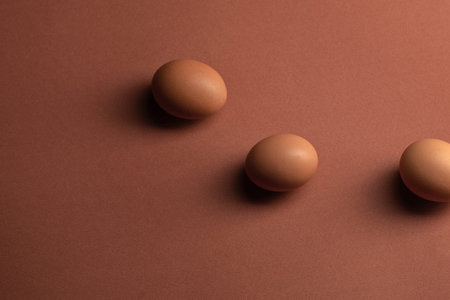 Regular chicken eggs from store on pinkish paper background