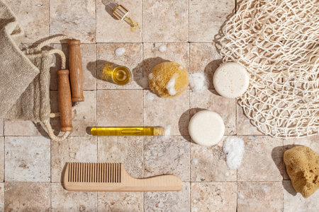 Zero waste care for skin - soap, dry shampoo, natural sea sponge with organic soap foam, wood brush, skin oil on earth toned stone tales top view direct sunlightの写真素材
