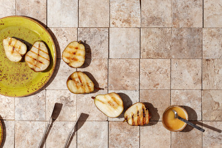 tasty grilled green pears on green craft plate and earth tones tales served with honey
