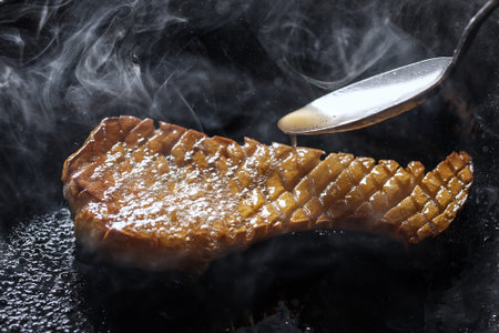 Pleurotus eryngii king oyster mushroom frying in iron cast pan creating beautiful steam
