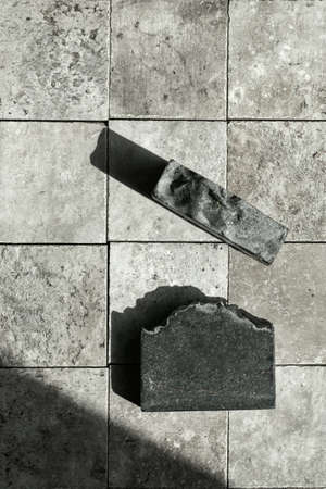Bamboo charcoal  handmade black soap bar on grey stone tales top viewの写真素材