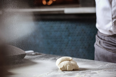 Making dough for bread by male hands in restaurant kitchen. Cooking concept.の写真素材