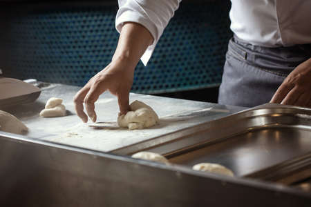 Making dough for bread by male hands in restaurant kitchen. Cooking concept.の写真素材