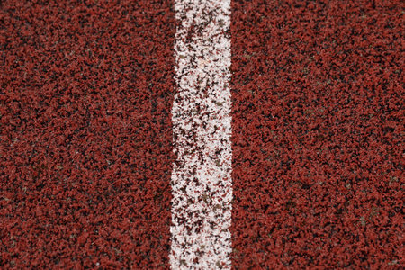 Red racing track with white line rubber texture in stadium texture background