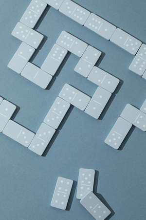 Light Blue wood domino pieces on light blue background. Leisure games concept.の写真素材