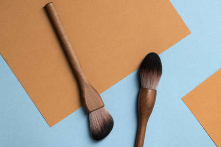 Set of natural wood vegan make up brushes on blue-beige background. Top view, copy space. Eco-friendly, no plastic zero waste conceptの写真素材