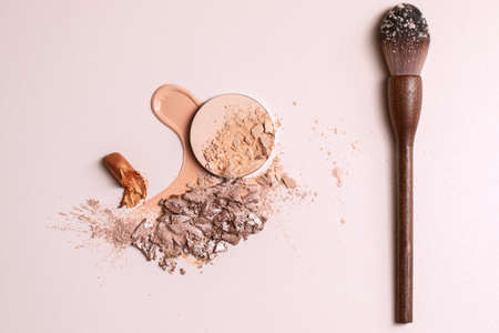 Crashed beige face finishing and liquid powder and zero waste wood finishing powder brush. Macro texture of make-up on beige backgroundの写真素材