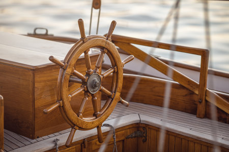 A close-up of instruments and wooden wheel of nautical vessel. Sailboat at sea backgroundの写真素材