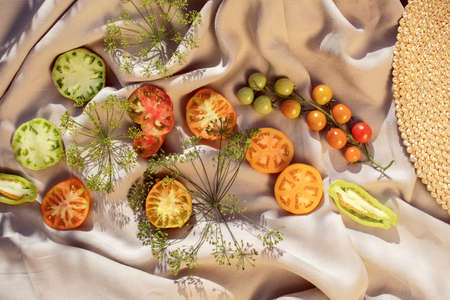 Organic fresh tomatoes with fresh herbs from home garden on a linen tablecloth. Healthy ecological harvest conceptの写真素材